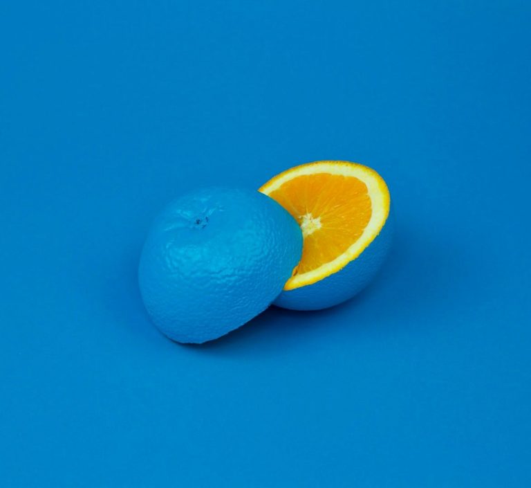 Orange coupée, la moitié intérieure est orange et l'extérieur est bleu. Fond bleu.