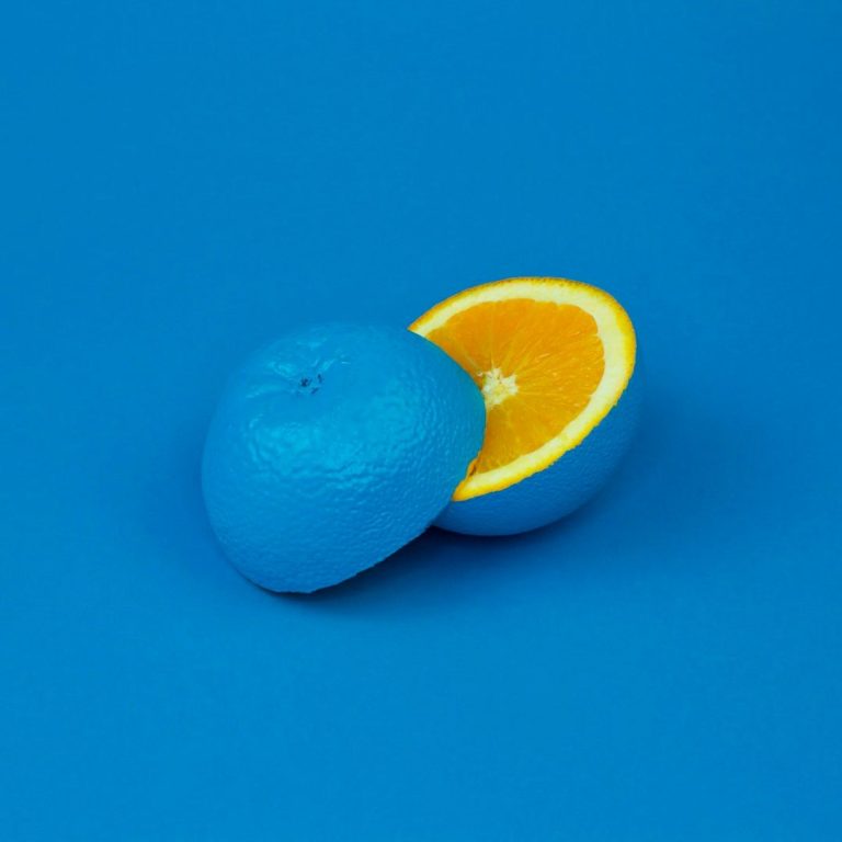 Orange bleue coupée en deux sur un fond bleu.